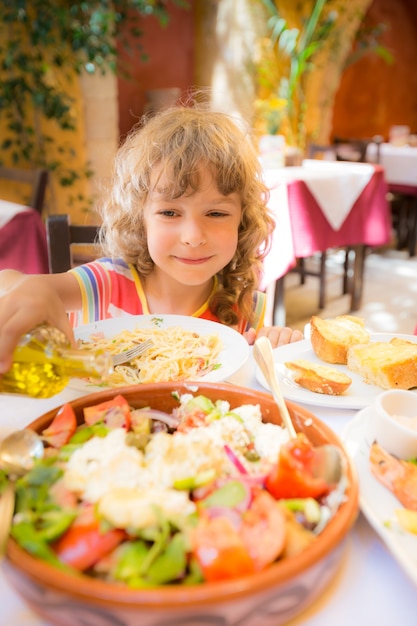 写真 屋外の夏のカフェで食事をする子供