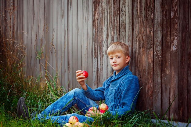 Child eating an red  apple outside in the garden.