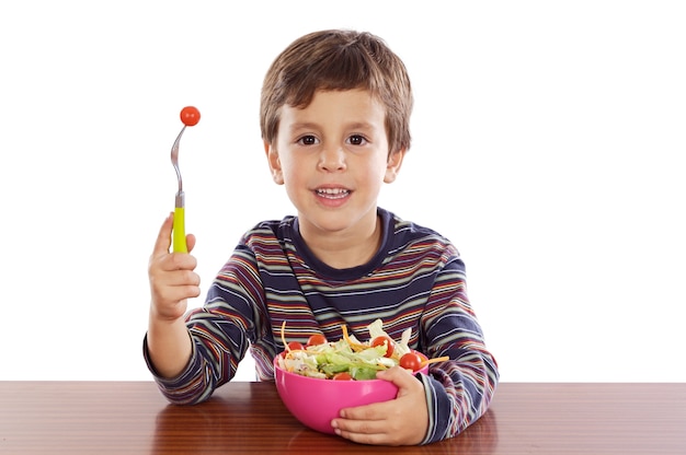 白い背景の上にサラダを食べる子供