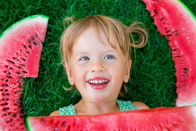 Child eating watermelon on the park in summer time