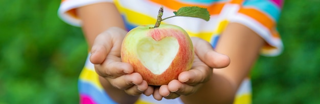 The child eats an apple in the garden. Selective focus. Kid.