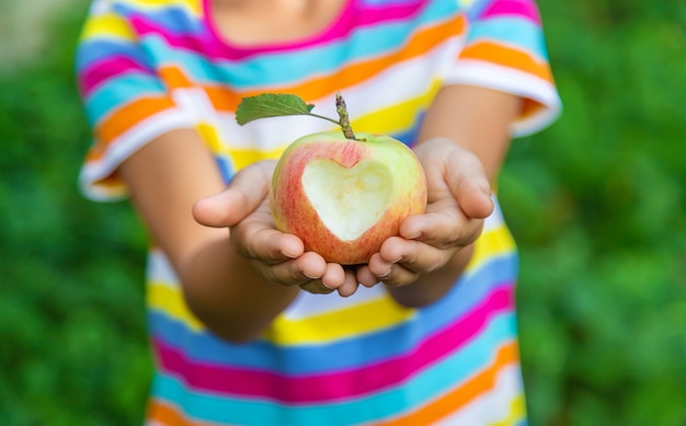 The child eats an apple in the garden. Selective focus. Kid.