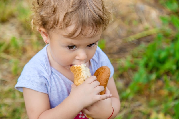 子供が公園でパンを食べる選択的な焦点