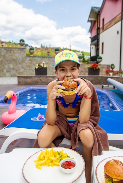 Photo a child eats a burger selective focus