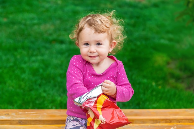 The child eats chips in the park Selective focus