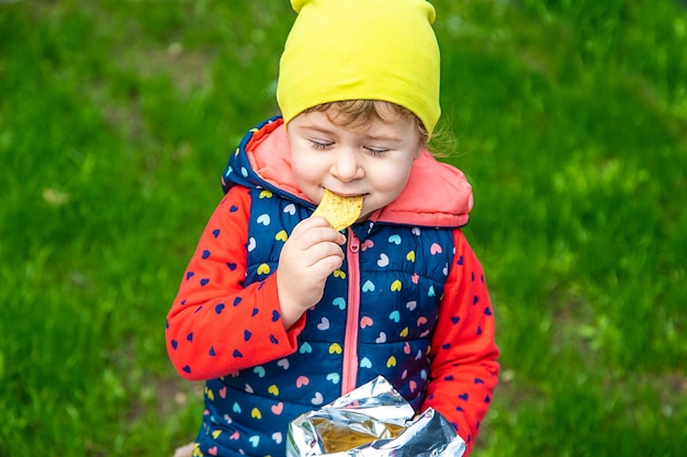 The child eats chips in the park Selective focus