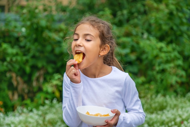 子供が路上でチップスを食べる。セレクティブフォーカス。