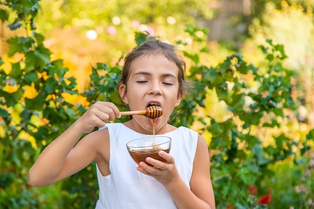 Ребенок ест цветочный мед. Выборочный фокус.