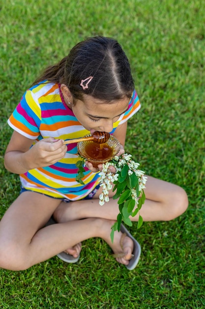 The child eats honey in the garden Selective focus