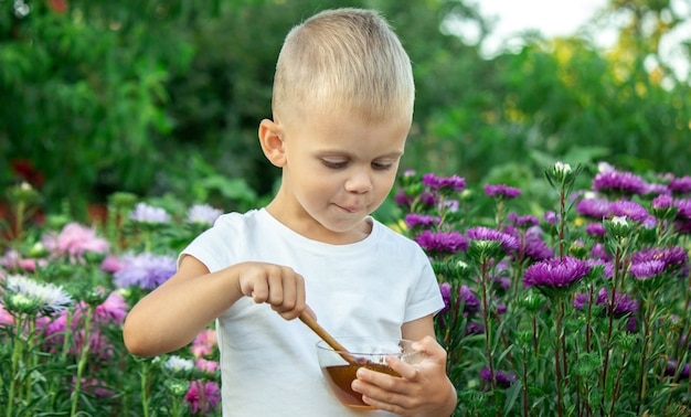 Child eats honey in the garden