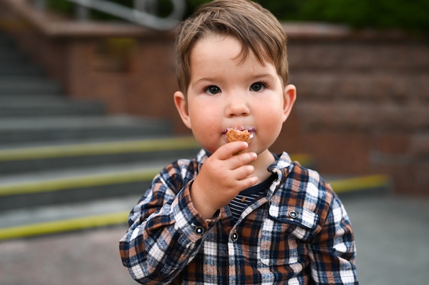 The child eats ice cream on the street