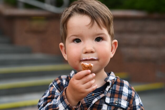 Il bambino mangia il gelato per strada