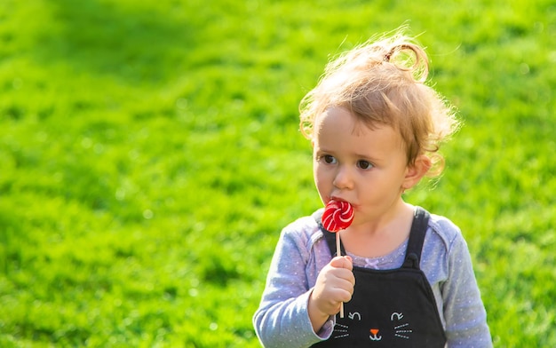 子供が公園でロリポップを食べる選択的な焦点