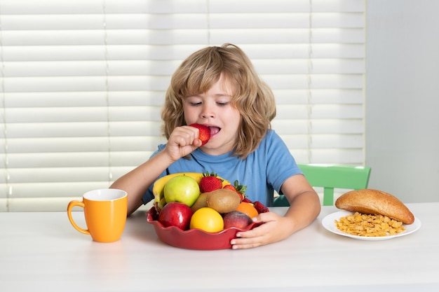 子供はイチゴのオーガニック フルーツを食べる
