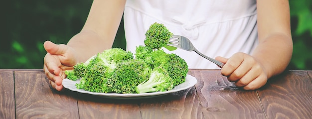 Child eats vegetables. Summer photo. Selective focus