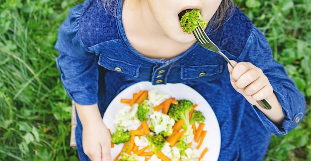 子供は野菜を食べます。夏の写真セレクティブフォーカス