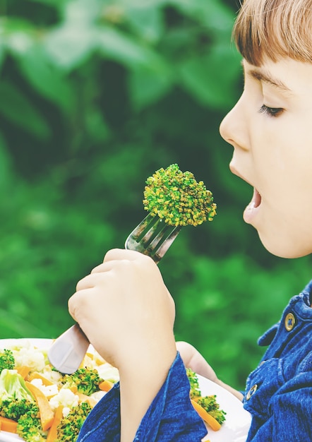 Child eats vegetables. summer photo. selective focus