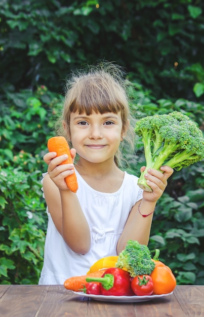 Летом ребенок ест овощи. Выборочный фокус. Люди.