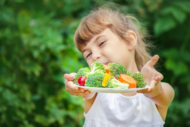 Child eats vegetables. 