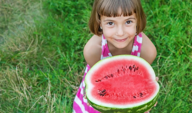 Child eats a watermelon in the garden