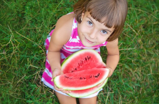 Child eats a watermelon in the garden