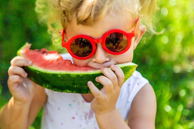 Photo a child eats a watermelon in the park selective focus food