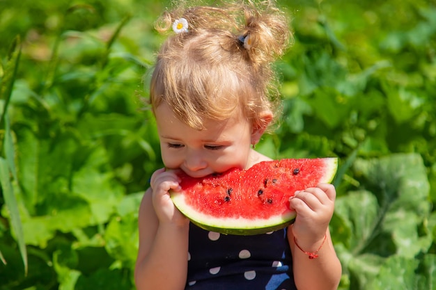 Un bambino mangia anguria nel parco messa a fuoco selettiva