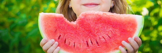 子供がスイカを食べます。写真。フード