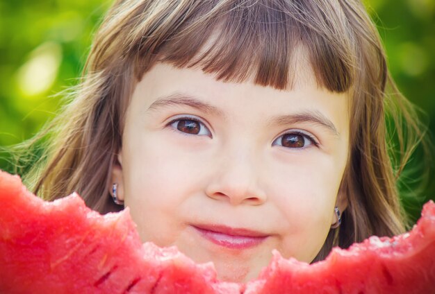 Un bambino mangia anguria. messa a fuoco selettiva cibo