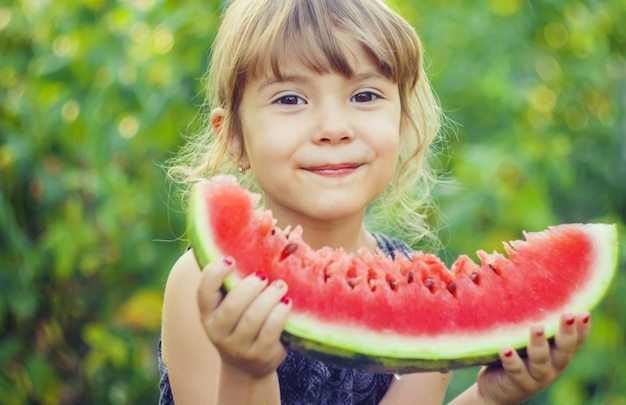 子供がスイカを食べます。セレクティブフォーカス自然。