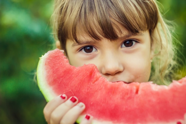 子供がスイカを食べます。セレクティブフォーカス自然。