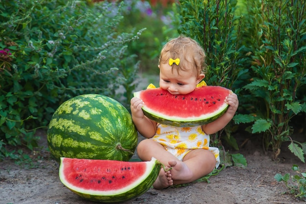 The child eats watermelon in the summer. Selective focus. Baby.