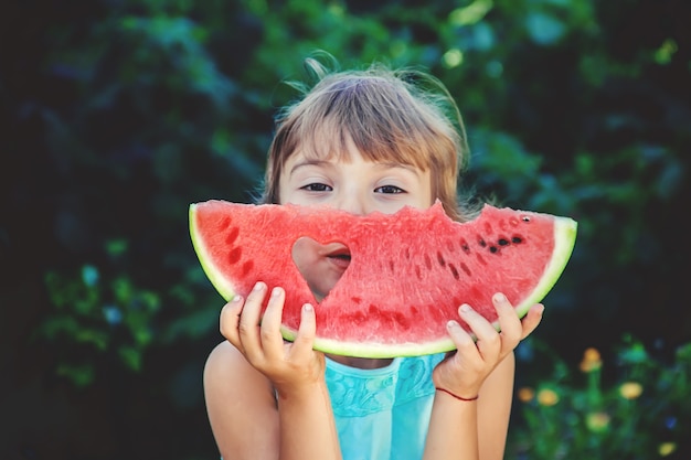 The child eats watermelon in summer. Selective focus.