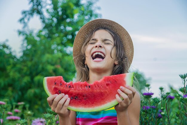 The child eats watermelon in the summer. Selective focus.