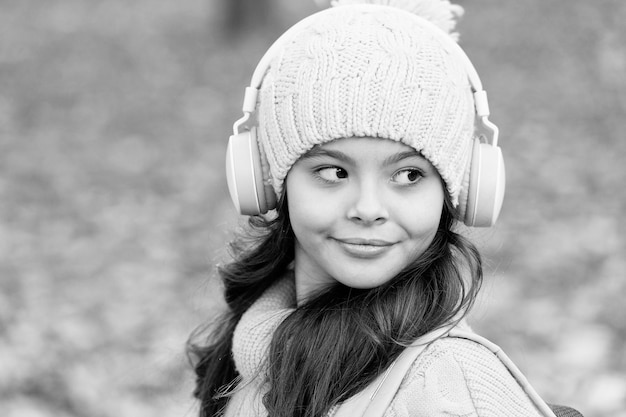 Child enjoy favorite song elearning brings knowledge girl in earphones and hat kid listen music in autumn park fall is a time for study school online education