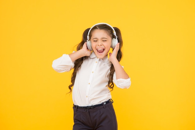 Child enjoy music sound Audio schooling Home schooling Small girl pupil headphones Child happy listen music Audio book Education and fun concept Online schooling Listening lesson Sing song