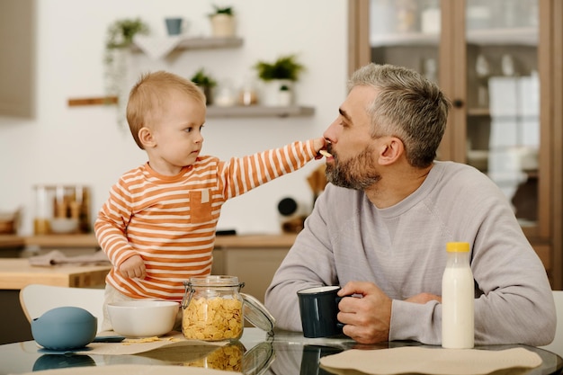朝食中に子供にを与える父親