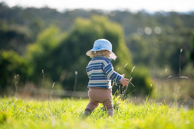 child in a field of long grass of pasture on a farm