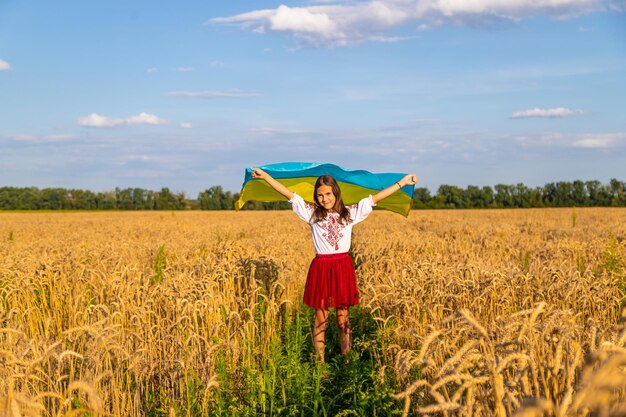 Child in a field of wheat with the flag of Ukraine Selective focus Kid