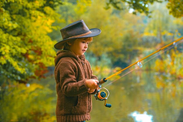 Child fishing at autumn lake kid with fishingrod