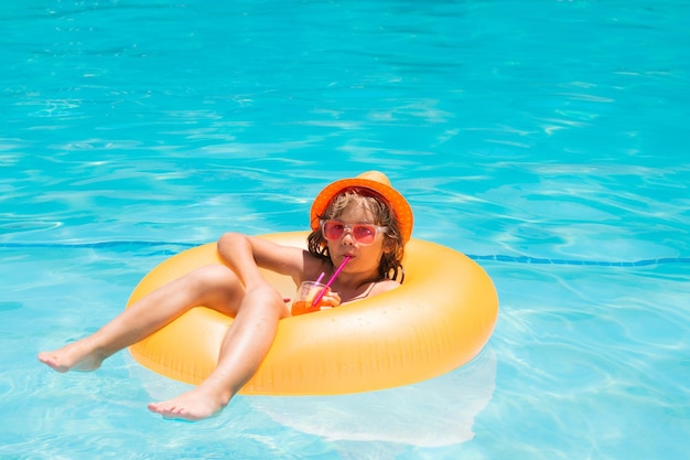 Child floating in pool child relaxing in pool drink summer cocktail summer holidays and vacation