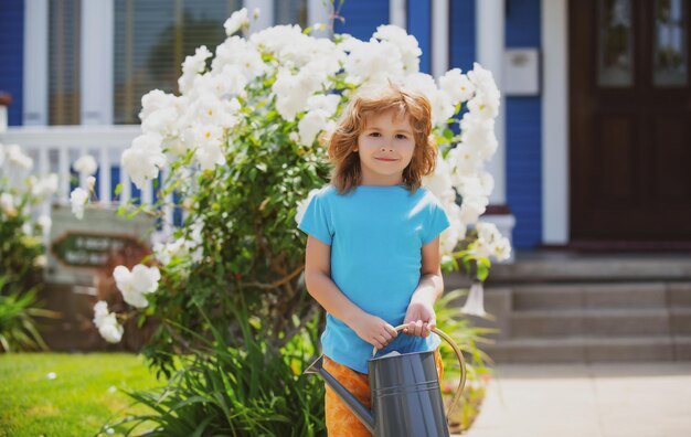 Child in flower garden Portrait of a kid working in the garden