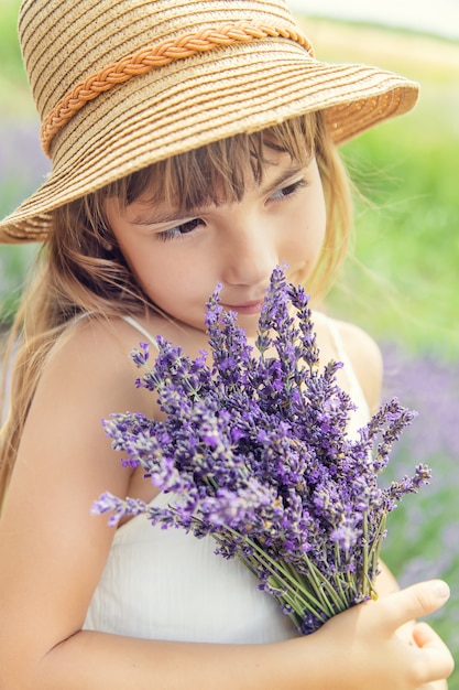 Foto un bambino in un campo di fioritura di lavanda.