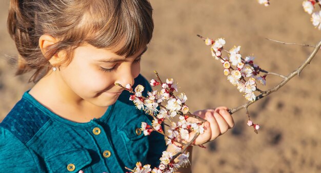 花の咲く木の庭にいる子供セレクティブフォーカス