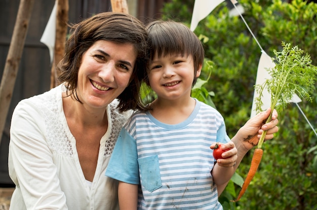 A child in a garden with carrot