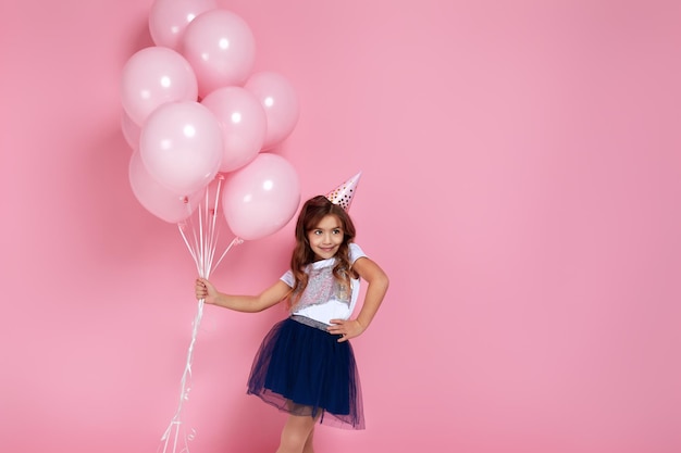 Детская девочка с пастельно-розовыми воздушными шарами