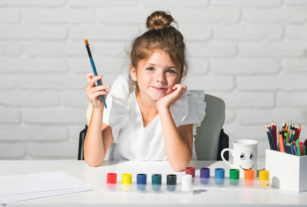 Фото Девочка в школе рисует красками дети художник творчество дети творческое образование приготов