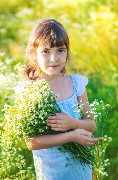 Child girl in a camomile field