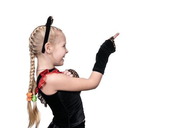 Child girl in a cat costume points in the sideways with the index finger of a bent hand isolated on a white background