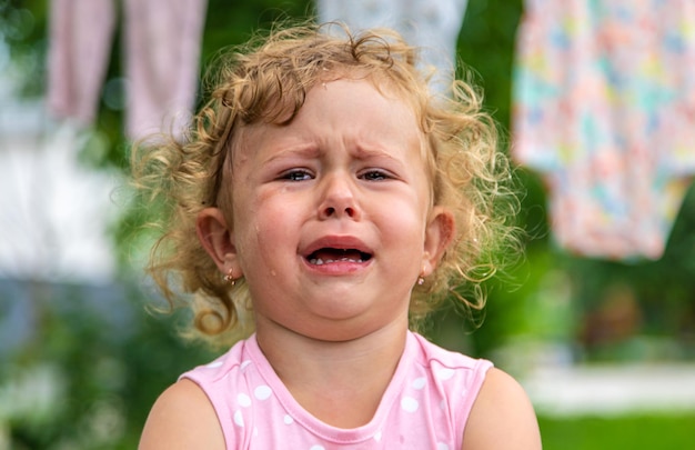 Foto bambina che piange nel parco messa a fuoco selettiva